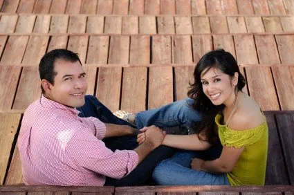 Cặp đôi ngồi nắm tay nhau trên sàn gỗ, minh họa diện vợ chồng hay hôn phu hôn thê
