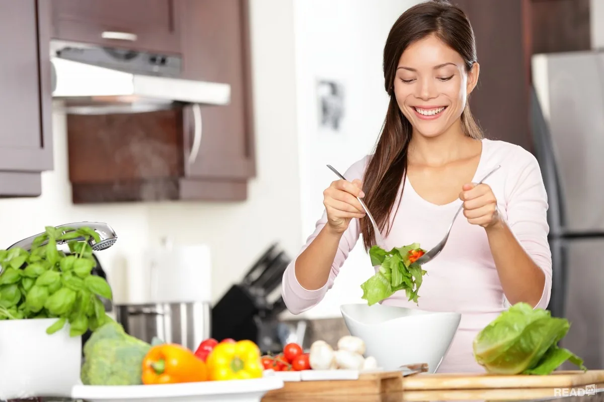 Người phụ nữ nội trợ trộn salad rau xanh trong bếp